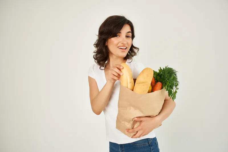 Милая брюнетка с пакетом продуктов из супермаркета, доставка на дом