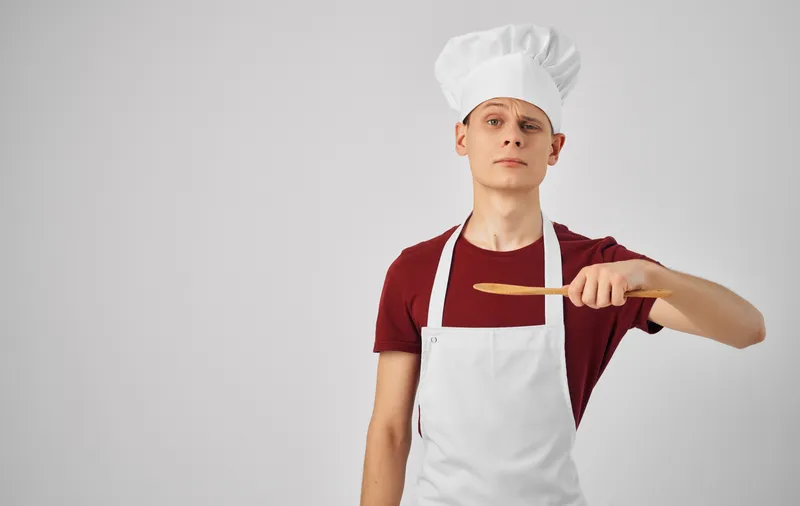Шеф-повар-мужчина с кухонной утварью, олицетворяющий приготовление еды и обслуживание