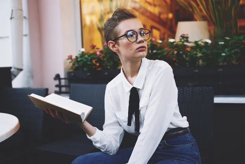 Студент на улице с книгой в руках