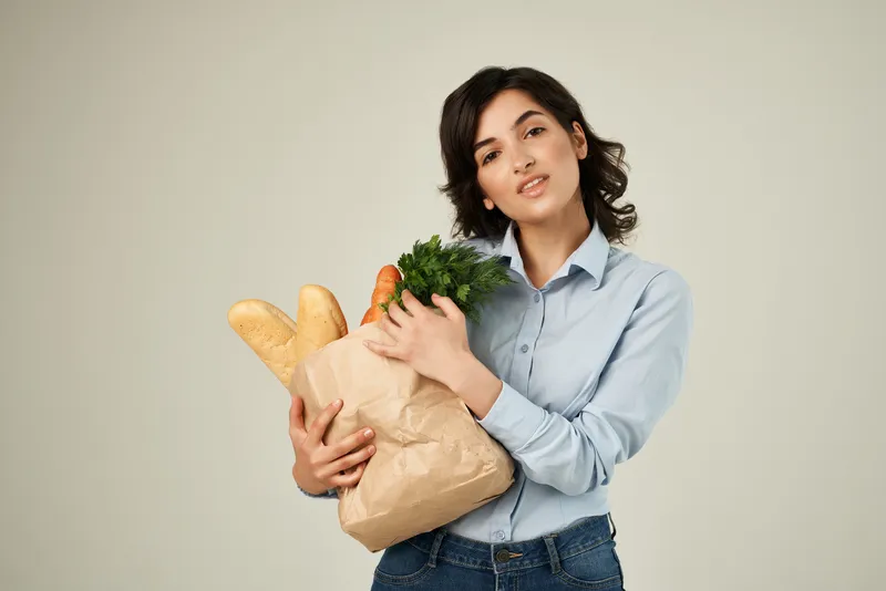 Женщина с пакетом продуктов, домохозяйка, совершает покупки в супермаркете