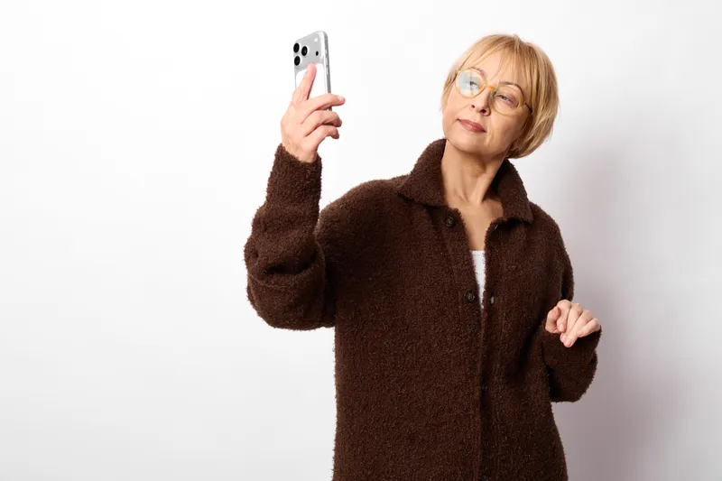 elderly woman smartphone glasses stress tired communication technology portrait indoor, holding a phone, looking overwhelmed with glasses on white background