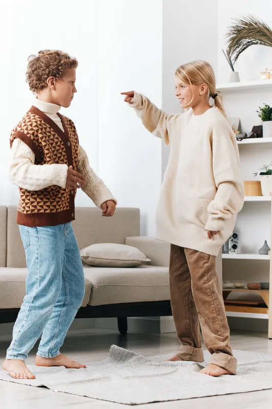 Authentic scene of children at home engaged in a playful school themed activity, capturing genuine moments of imagination, learning, and daily lifestyle in a cozy, sunlit living space.