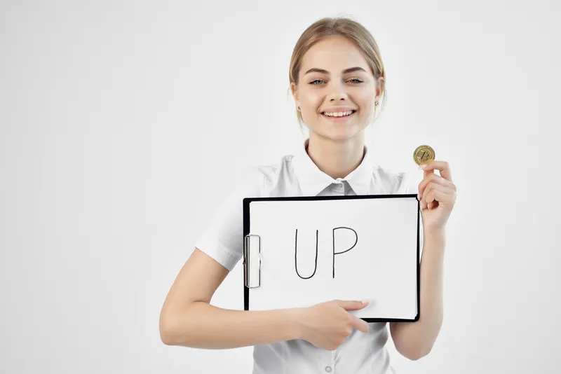 Женщина держит папку с надписью «up» — криптовалюта, финансы