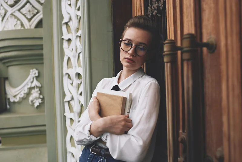 Студент с книгой в руках на открытом воздухе, читает, образование