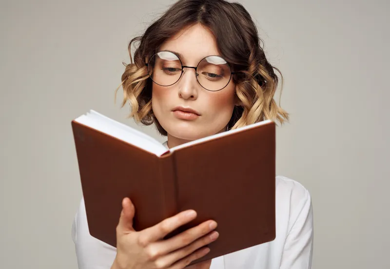 Образованная женщина с книгой в руках, в очках и белой рубашке, образовательная модель