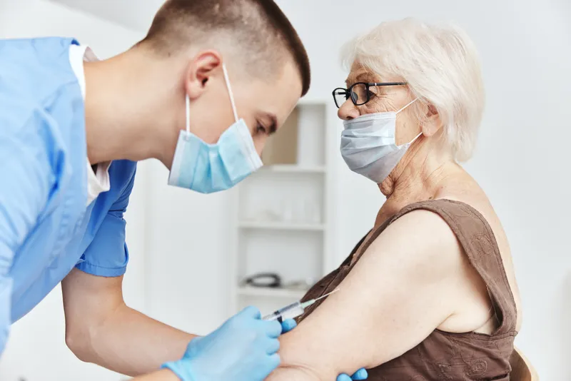 Пожилая женщина в больнице с вакцинационным паспортом пациента на лечении