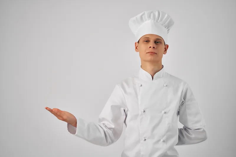 Мужчина в униформе повара жестикулирует рукой, профессиональная работа по приготовлению пищи