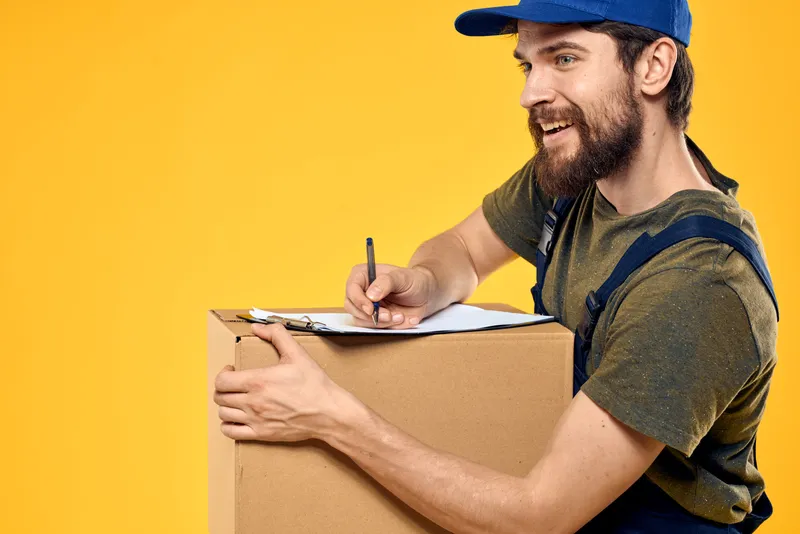 Рабочий-курьер доставляет коробки с документами на жёлтом фоне