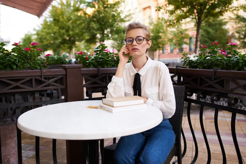 Студент с книгой в руках читает на прогулке на свежем воздухе, образование