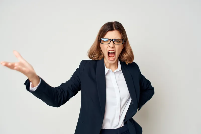 Жизнерадостная женщина в деловом костюме позирует с рабочими документами в офисе