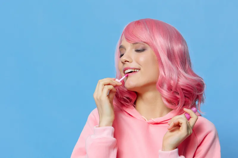 Женщина красит губы косметикой Glamor на изолированном фоне