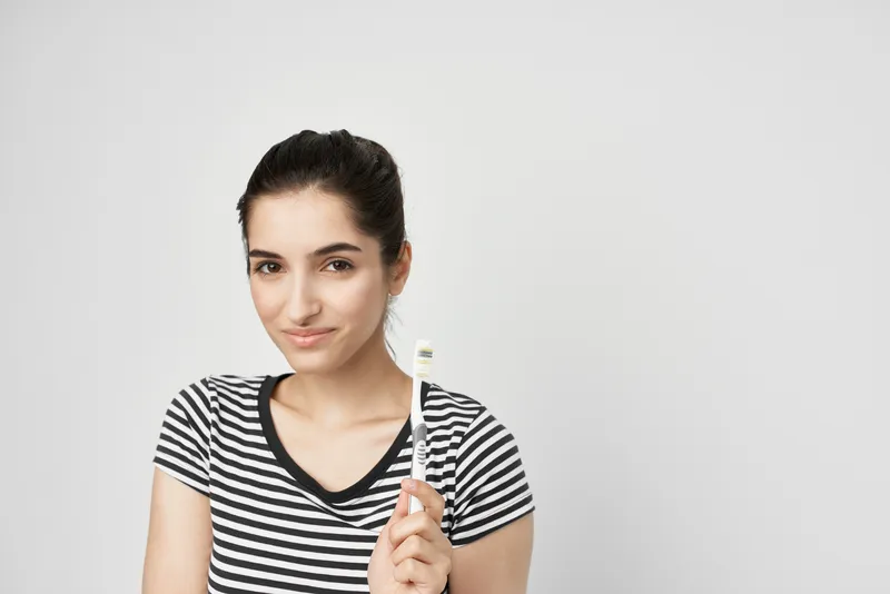 Женщина в полосатой футболке с зубной щеткой, уход за полостью рта, гигиена