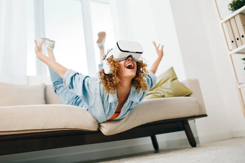 Виртуальная реальность: радостное indoor-развлечение современной женщины, заглядывающей в будущее с белой VR-гарнитурой
