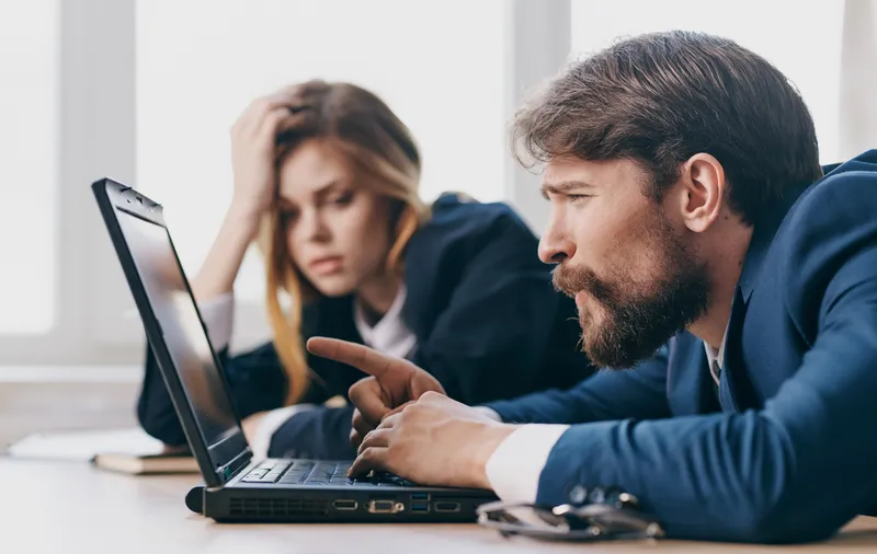 Уставшие мужчина и женщина на работе, коллеги за ноутбуком, профессионалы