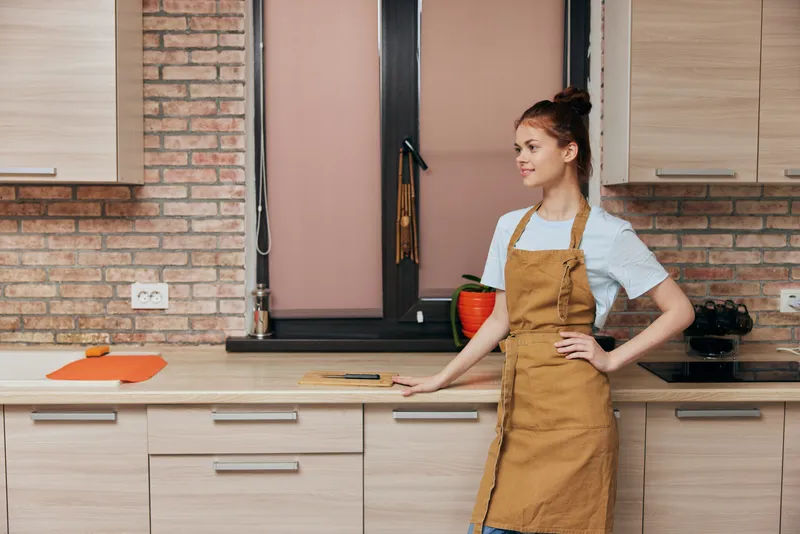 Домохозяйка в коричневом фартуке на кухне, домашняя жизнь