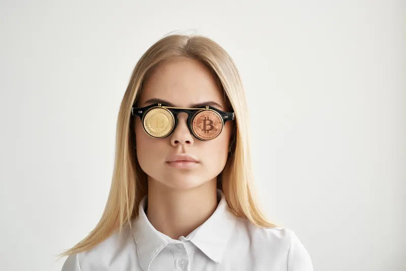 Веселая женщина в очках с символикой Bitcoin, связанная с технологиями майнинга