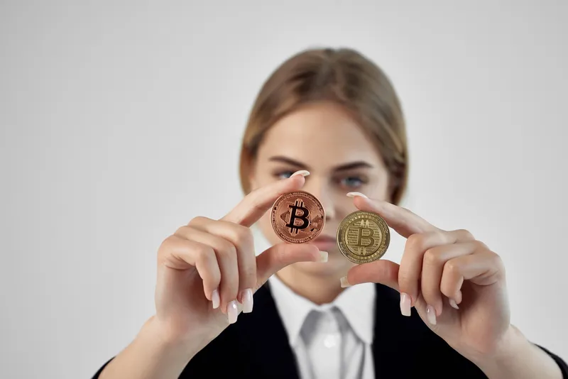 Бизнесвумен держит в руках биткоин на изолированном фоне