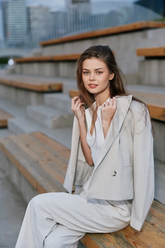 woman in beige suit sitting on wooden stairs outdoors natural light urban fashion style casual confident expression woman beige suit wooden stairs urban background