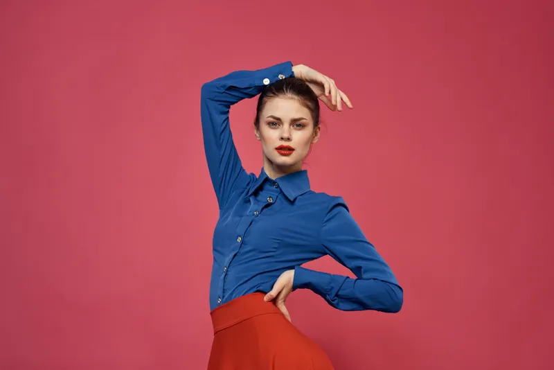 Женщина в голубой рубашке и с красными кубиками на розовом фоне