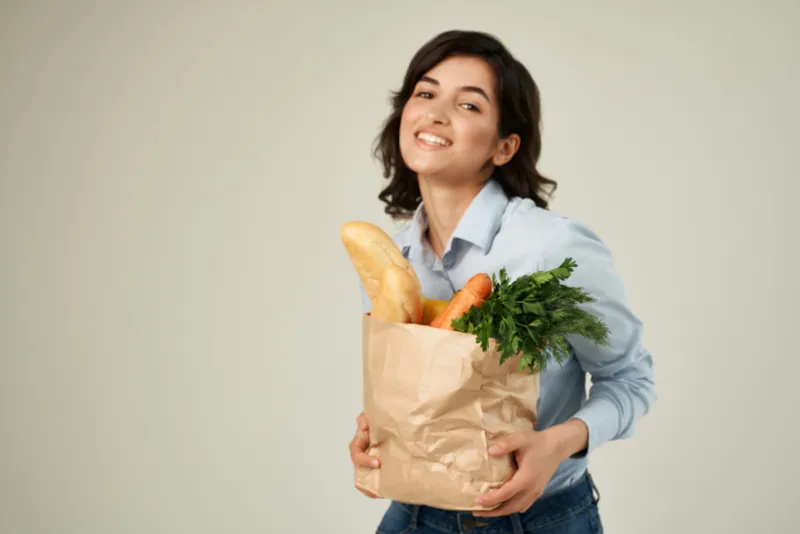 Брюнетка с пакетом продуктов в супермаркете