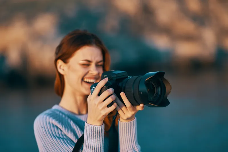 Женщина-туристка с фотоаппаратом на природе