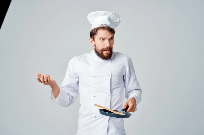 Весёлый шеф-повар на кухне ресторана посуды