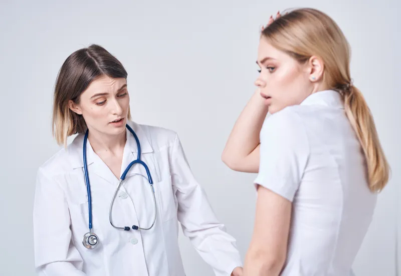 Пациент пришел к врачу с моделью стетоскопа, символизирующей проблемы со здоровьем