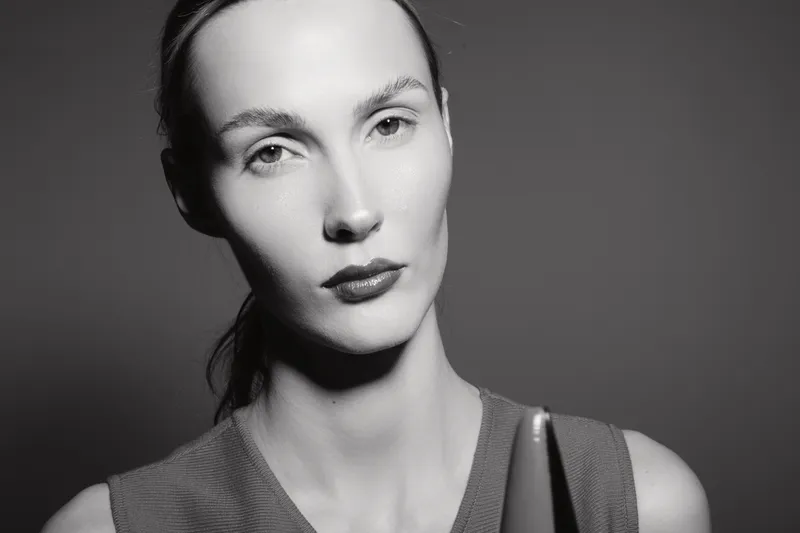 Portrait of a serious white woman with pale skin looking at camera in black and white studio photo. Concept for beauty, emotion, and natural expression in monochrome style.