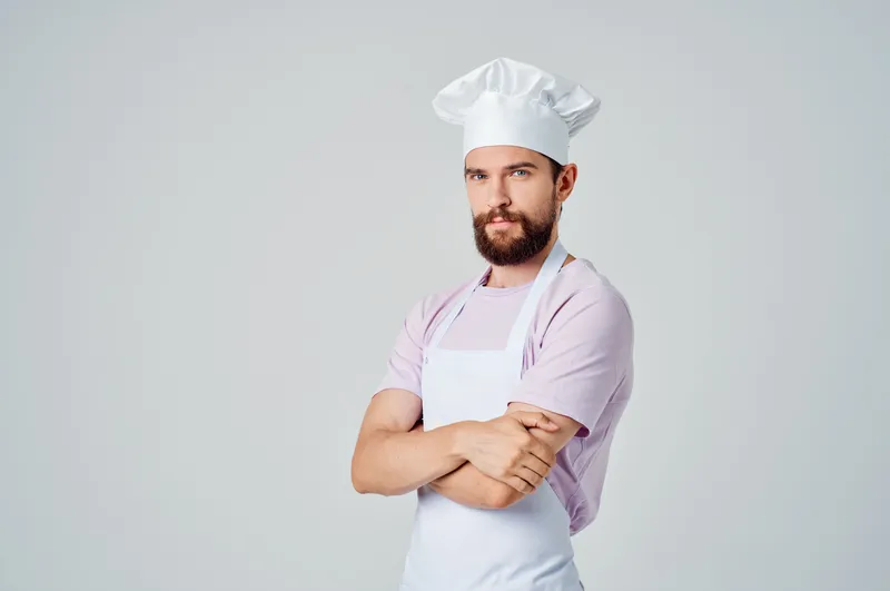 Профессиональный шеф-повар работает на кухне ресторана, занимаясь приготовлением блюд