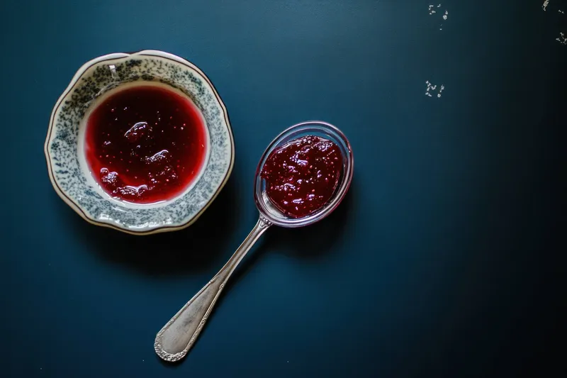Вкусное домашнее ягодное варенье, поданное в винтажной миске, подчеркивающее сезонные вкусы и идеалы здорового питания благодаря насыщенным, ярким цветам