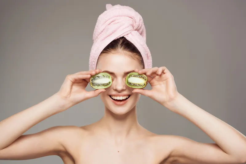 Красивая женщина с обнажённым телом держит в руке киви, кадр обрезан