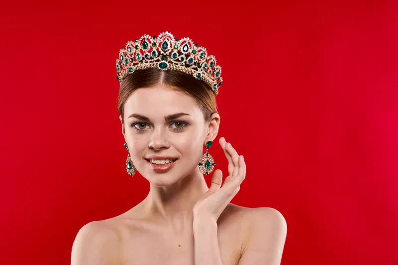 Привлекательная женщина с обнаженными плечами, украшения, косметика, позирует в студии