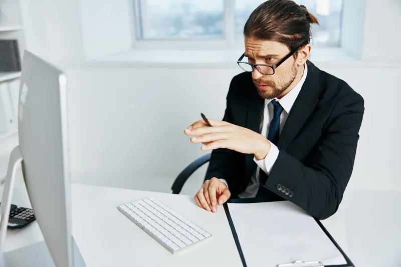 Офисный работник в костюме работает в офисе с телефоном