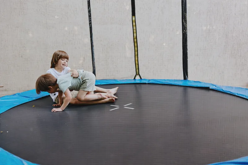 Happy children playing on a trampoline, enjoying their carefree moments in bright, playful surroundings filled with joy and laughter.