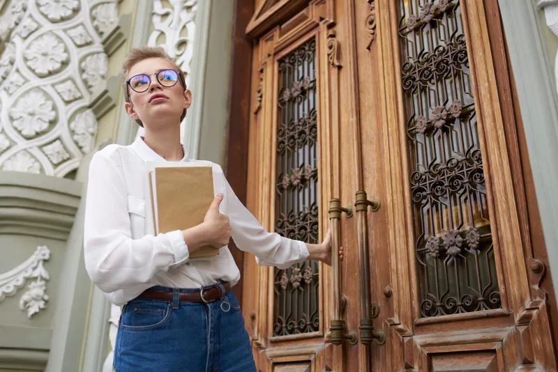 Студент с книгой в руках на открытом воздухе, читает, образ жизни