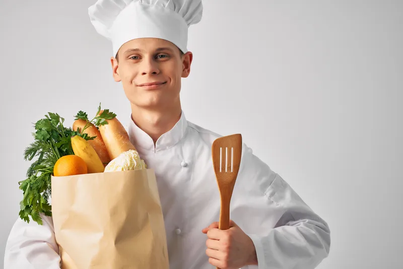 Мужчина в форме шеф-повара с упаковкой продуктов, работа в ресторанном сервисе