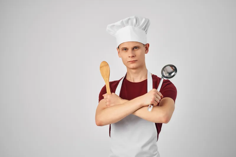 Мужчина в форме повара готовит на кухне, отражение образа жизни