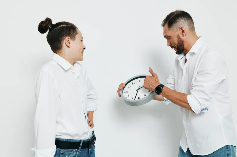 A professional man and a younger colleague stand before an isolated colored backdrop, sharing a confident moment in a business setting as they exchange dialogue and express teamwork.