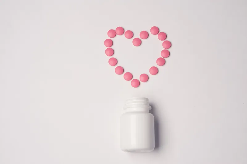Белая банка с таблетками на светлом фоне, вид сверху, медицина, здоровье, витамины