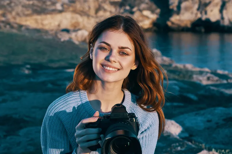 Красивая женщина-фотограф снимает пейзаж на камеру