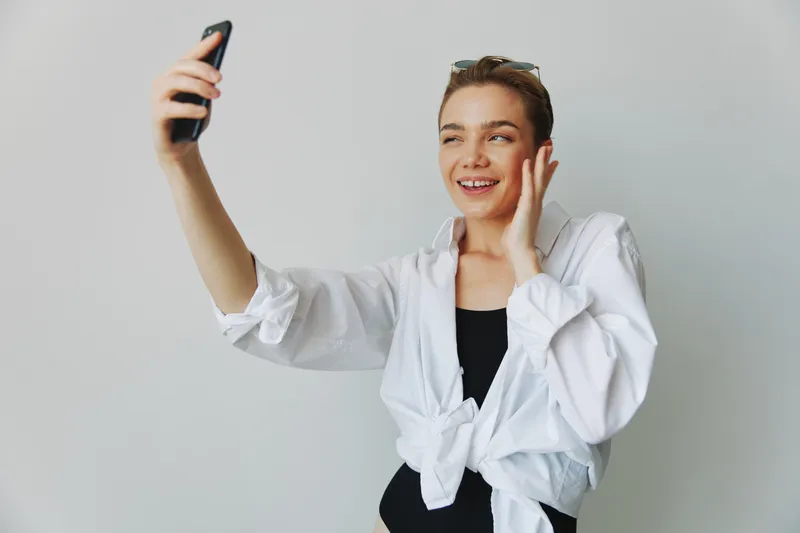 Девушка-подросток, ведущая блог, фотографирует и снимает себя на видео на свой телефон для создания контента для социальных сетей