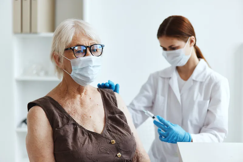 Пожилая женщина-пациентка в больнице для вакцинации и получения паспорта COVID-19