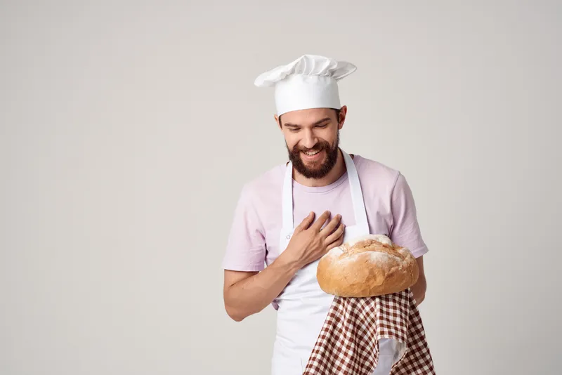 Мужчина в форме шеф-повара работает, занимается кулинарией и выпечкой