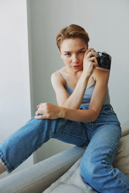 Женщина-фотограф снимает в студии на старую плёночную камеру