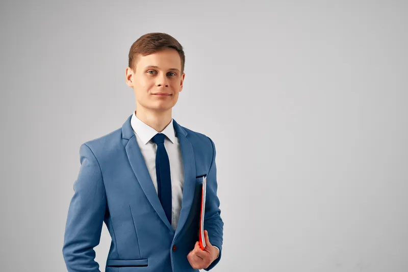 Мужчина в костюме с красной папкой с документами, работающий менеджером или официальным лицом