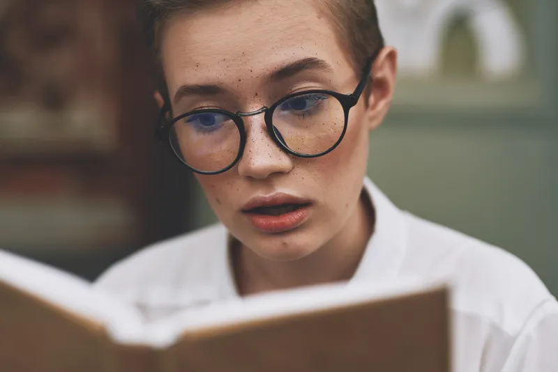 Образование, женщина в очках, студентка возле института, книга в руках, модель, крупный план