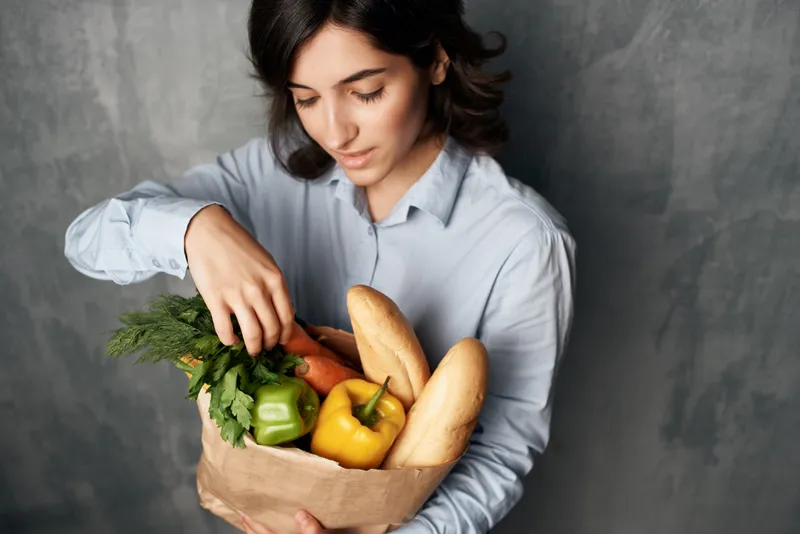 Брюнетка с пакетом продуктов, доставка из супермаркета, органические продукты