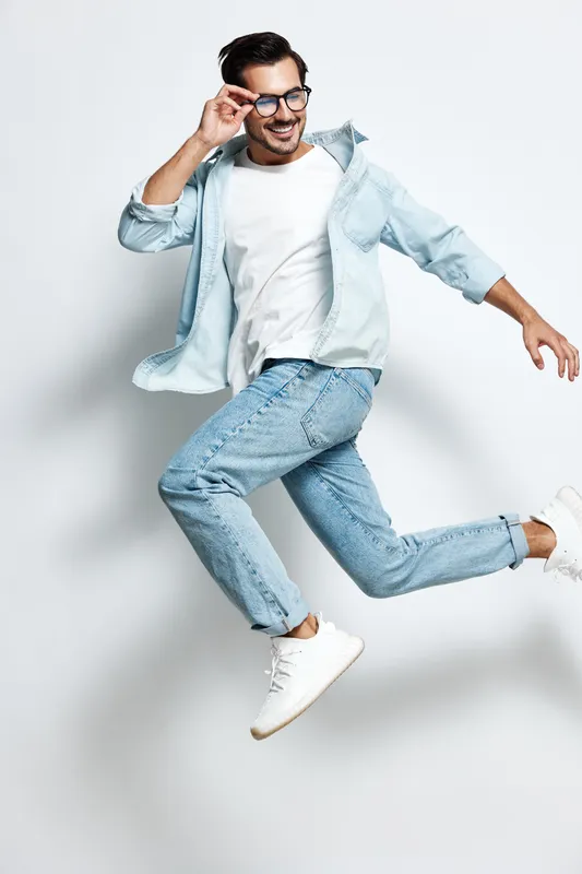 Full body joyful smiling young man wear stylish casual outfit jump in air looking at camera with confidence isolated on plain light background studio portrait.