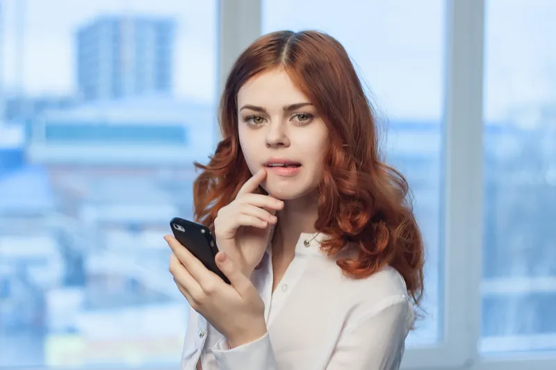 Женщина-менеджер с телефонами в руках, общение, офисная работа