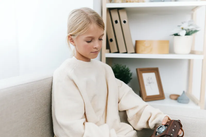 Authentic scene of a young child engaged in a playful activity at home, highlighting school themes and everyday life, with a cozy living space and calm, focused mood.